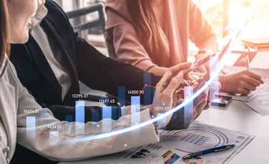Business professionals engage in financial analysis using digital devices, showcasing charts and data in a collaborative office setting, illustrating growth and strategy. Scalp