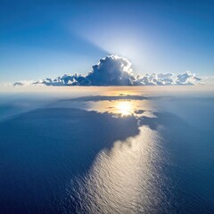 Sea illuminated by sun behind cloud