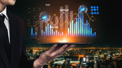 A businessman stands outdoors, holding a tablet that displays vibrant financial charts and data visualizations, set against a modern city skyline at night, showcasing trends and analytics. Scalp