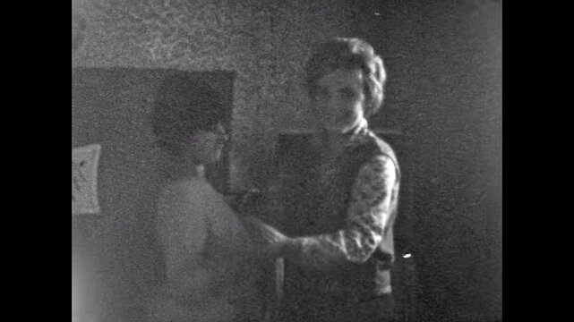 Happy women dancing together at home, holding hands and smiling, warm moment of friendship. An old film. Female friendship. Fun times together. Old film. Archival retro 1960s. Vintage archive.