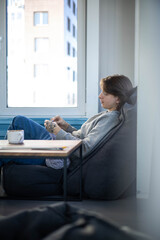 Feminine hipster man crochet handmade use hook knitting needles and wool yarn relaxing on couch