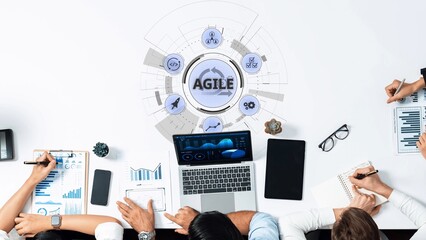 A modern office setting featuring a diverse team engaged in agile methodology, utilizing data visualization tools on a workspace table for effective collaboration and project management. Raster