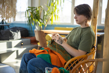 Hipster feminine male crochet handmade knitting hobby with colored yarn and hook at wooden interior