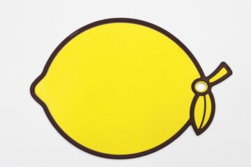 Yellow plastic cutting board lemon shaped isolated
