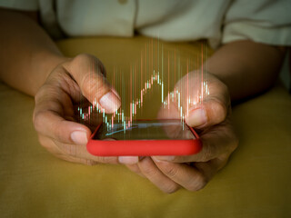 Close-up hands holding smartphone with stock market chart overlay, symbolizing online trading, investment tracking, financial analytics, and modern technology for mobile stock market monitoring.