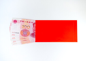 Red envelope ANG BAO with 100 Chinese yuan banknotes on white background. Chinese New Year, gift...