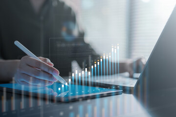 A person analyzing financial data on a digital fintech dashboard using a tablet and stylus, showing charts, metrics, and business performance visualization in a modern data-driven environment.