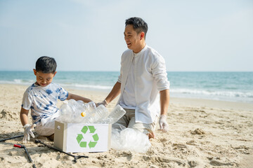 A father and son collecting plastic waste on the beach, promoting environmental protection, recycling, sustainability, and responsible eco-friendly habits while enjoying outdoor activity together.