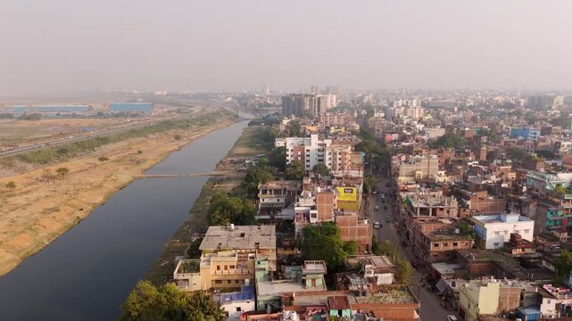 Tier 2 Patna city crowded residential neighbourhood with JP Ganga Path on left under hazy sky, drone shot