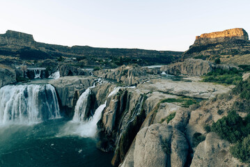 Aerial View of Gigantic Shoshone Waterfall and hydroelectric power plant, with the massive water cascading down into a serene pool in the Snake River. 