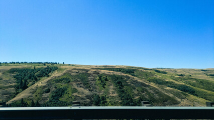 Extreme plateaus under a clear blue sky, near Deadman Pass. Taken from a moving car along the I-84 in eastern Oregon.