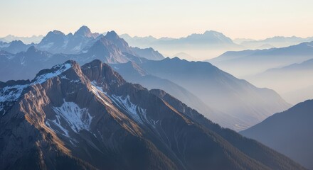 Layered mountain ranges fade into soft atmospheric haze during dawn or dusk