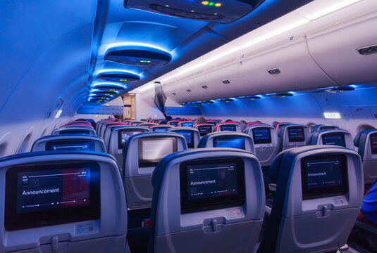 Interior view of an illuminated Delta Airlines Airbus A320 passenger cabin with an announcement in progress on the display screens in Atlanta, Georgia, December 4 2025.