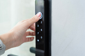 Hand pressing smart digital door lock keypad for secure access modern home technology safety and...