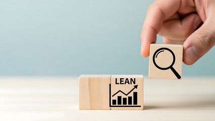 Hand placing a block with a magnifying glass icon next to a block with the word LEAN and a growing graph.