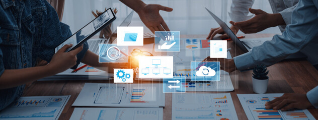 A diverse business team collaborates on a project in a modern office, utilizing digital interfaces and charts to enhance productivity and drive results. Trope