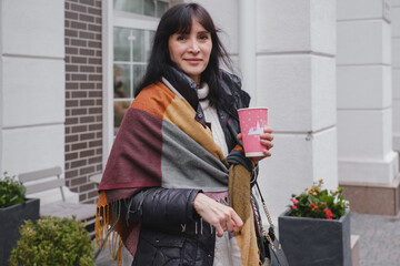 Urban lifestyle shot of woman with handbag opening white door, returning home or visiting business in city neighborhood. Woman going for walk