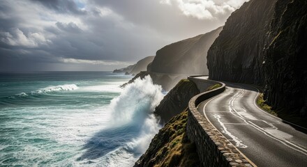 Winding coastal roadway hugs steep cliffs beside turbulent ocean waves under dramatic sky