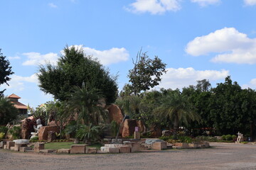 An outdoor recreational area under a clear sky. In the center of the frame is a focal point with a...