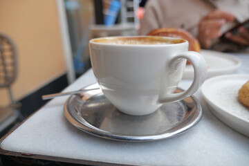 Enjoying coffee and pastry while sitting at a cafe table