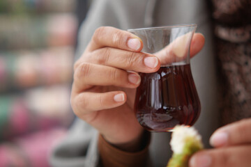 Enjoying Turkish tea with a snack in a busy cafe setting