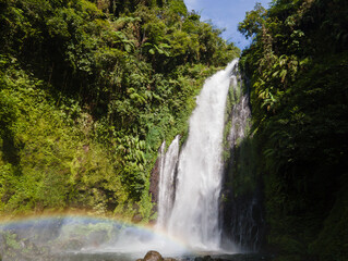 Fototapeta premium Aerial view of Gomblang Waterfall with Rainbow in Lush Forest, Java Island, Indonesia