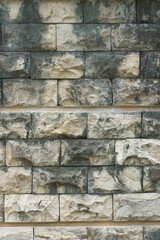 Background texture of a rough natural stone wall made of irregular rectangular masonry blocks.