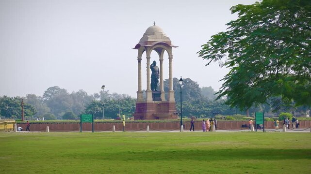 Delhi, India, November 28, 2025. Subhash Chandra Bose statue standing under the ceremonial canopy in the India Gate complex with visitors in the landscaped park