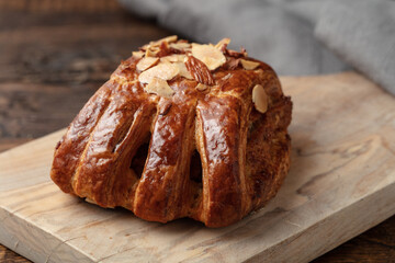 Close-up of a bear claw donut dessert on a small wooden  cutting board.  