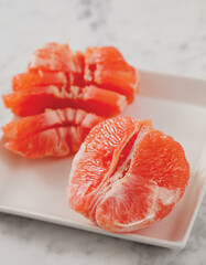 Close-up of a fresh-cut grapefruit on a white plate