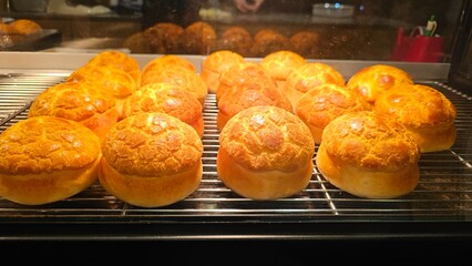 The process of making baking keep warm delicious Hong Kong-style pineapple bun with slice of cold butter by a bakery shop staff — traditional sweet pastry street snack cute mushroom shape bread
