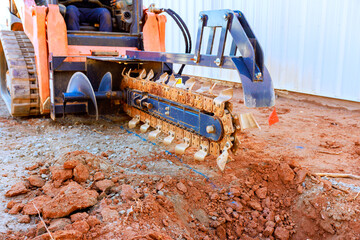 Construction machine digs prepares ground in worksite for future projects