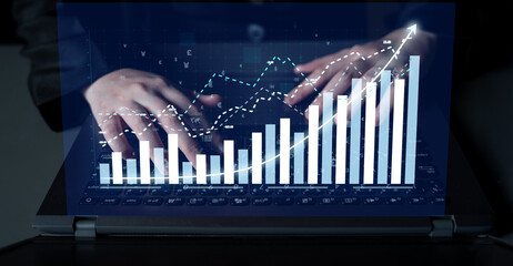 A professional workspace showcasing hands typing on a laptop, featuring digital charts and graphs that demonstrate financial growth and data analysis. Impute