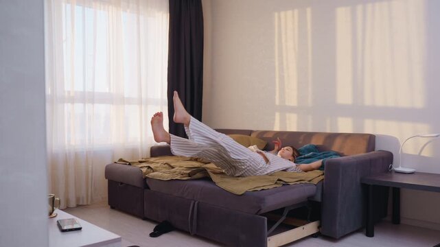 Calm Restful Afternoon, Woman Lying Peacefully On Cozy Sofa Bed, Exhausted Female In Pajamas Unwinding On Sofa, Relaxed Young Lady In Pajamas Enjoying Peaceful And Restful Afternoon At Home
