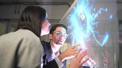 Two people are discussing cybersecurity in an office. They interact with a digital screen showing data and security graphics. The focus is on collaboration and technology use. - Powered by Adobe