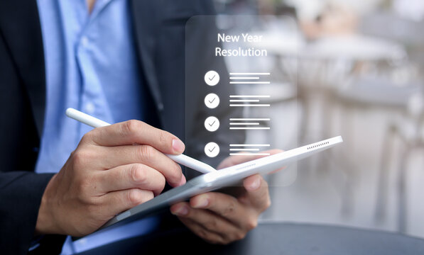 close up manager businessman hand use stylus pen to write and check to do list for remind of new year resolution concept