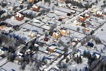Aerial view of snowy suburban neighborhood with residential houses