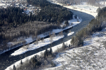 Obraz premium Aerial view of winding river with floating ice