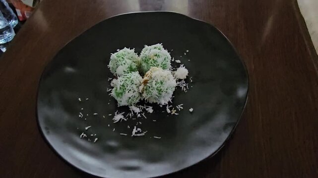 fried fish in a panKlepon or Kelepon or Kalalapun or Onde onde or Buah melaka or Kuih melaka is a sweet rice cake ball filled with molten palm sugar,coated in grated coconut,the green colored glutinou