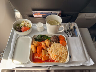Meal served on a flight from Penang to Singapore features rice and vegetables alongside salad and drink
