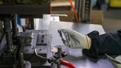 Metal Press Processing and Worker Inspecting Fabricated Parts