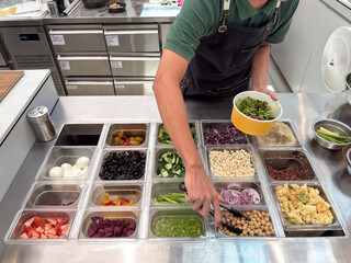 Salad preparation with various ingredients in fresh cafe kitchen setting