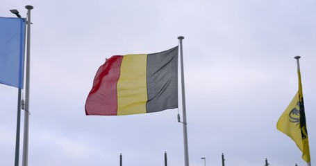 Waving flag of Belgium against a cloudy sky The flag is a national symbol of Belgium representing the country's government politics and Belgian culture.