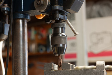 Close Up of an Older Bench Drill Press Chuck and Vice in a Workshop