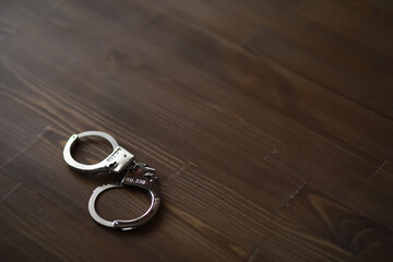 Handcuffs on Wooden Floor - Law Enforcement, Crime, Security, Arrest Symbol