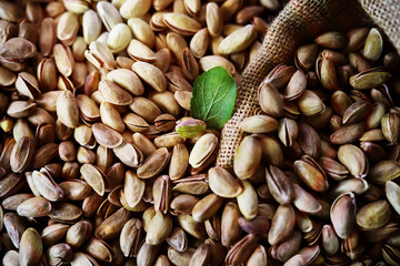 Roasted salted pistachios. Dried pistachios in small sack on  table.