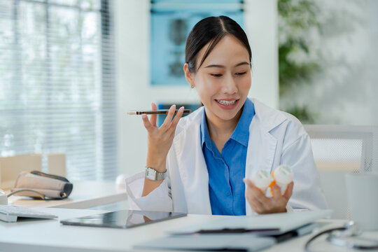 Asian female doctor consultation or tell patients the results of examinations by mobile phone and holding tablet at clinic hospital.Concept of telemedicine,remote consultation and modern healthcare