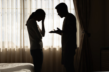 Silhouette of a Distressed Couple Arguing in a Bedroom Setting