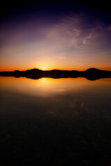 夜明けの湖の劇的な日の出の場面。水面に反射する空。