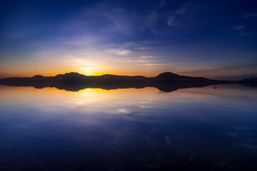 深い青の空が水面に反射する湖の劇的な風景。
